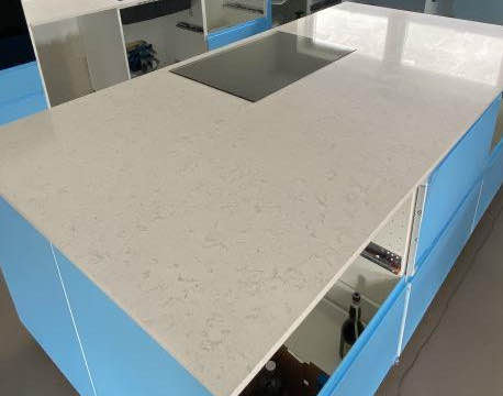 Detaljebillede af sort højblank bordplade i moderne køkken